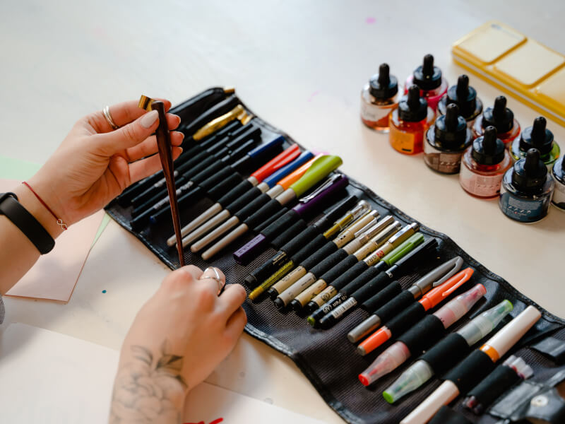 A collection of ink and calligraphy pens in a roll up holder.